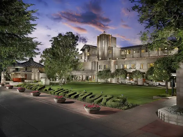 A large building with a lush green lawn in front of it.